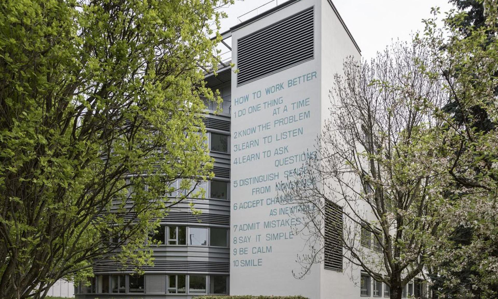 Public pavement with a view of How to Work Better on the wall at Binzmühlestrasse 14, Oerlikon.
