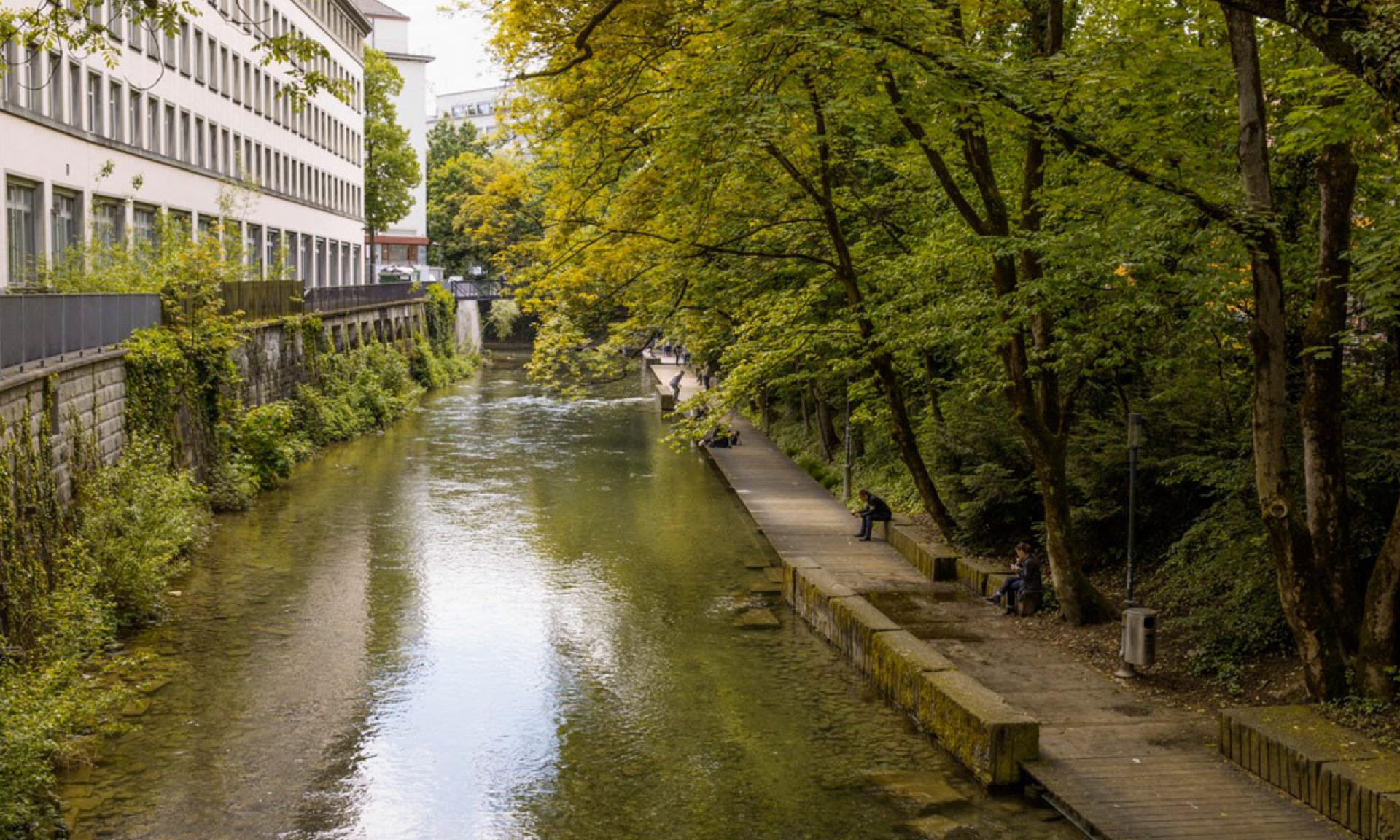 Open public section of the Schanzengraben promenade, on the walkway beside the water and clear of stairs.