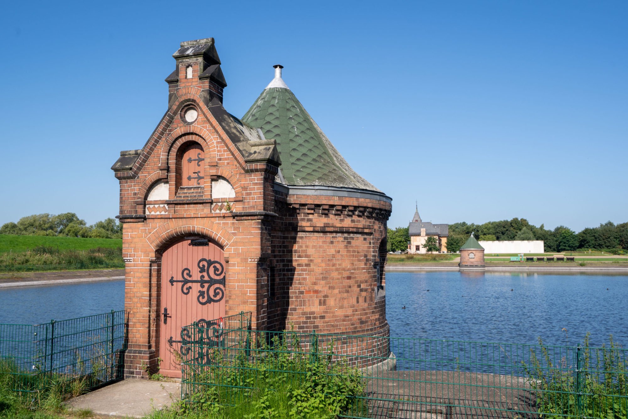 Public visitor path beside a former filter basin and its valve houses at Wasserkunst Kaltehofe.