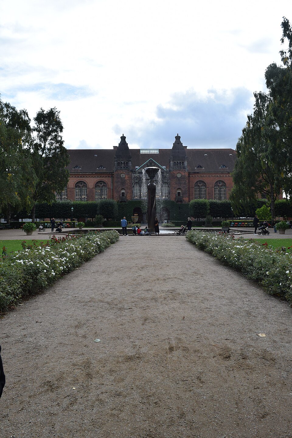 Public path beside the central pond in the Royal Library Garden, reached through the open entrance from Proviantpassagen.