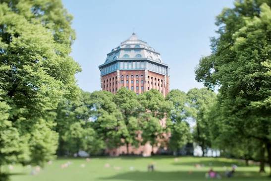 Public Sternschanzenpark path with a clear view of the historic water tower, outside the hotel entrance.