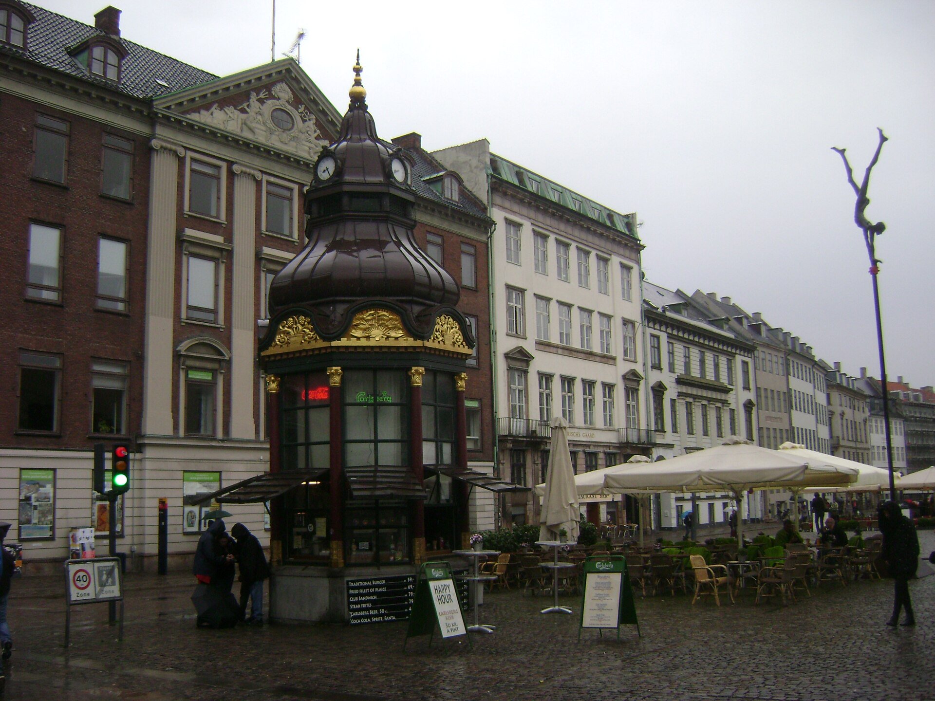 Public square beside the small historic kiosk at Nytorv 1F, outside its service area and without blocking customers.