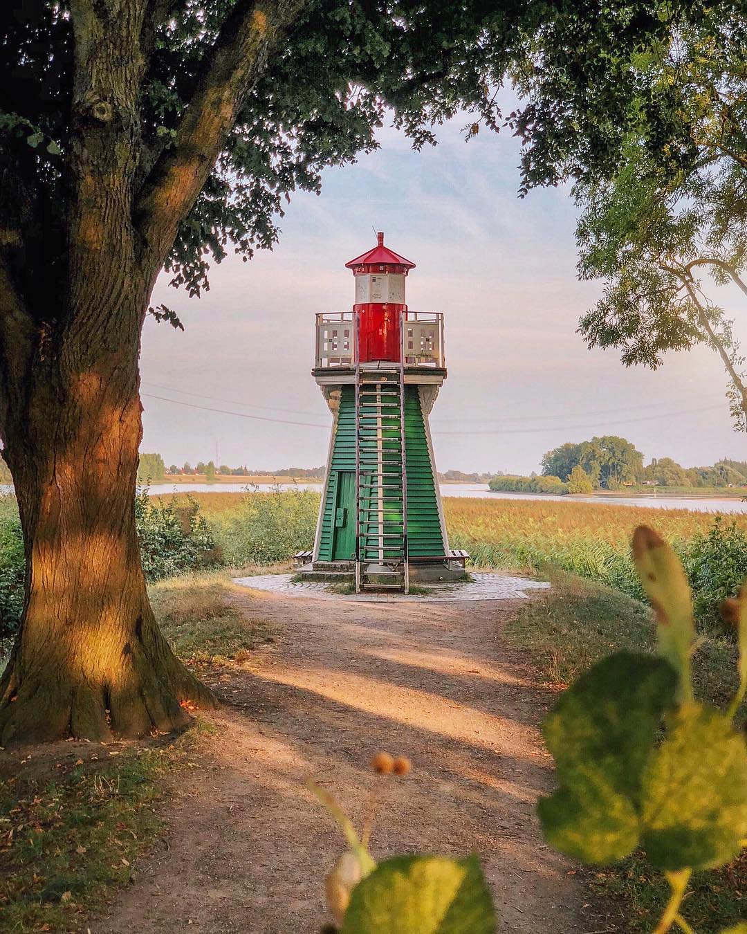 Public Bunthäuser walking path beside the small lighthouse, set back from the riverbank.