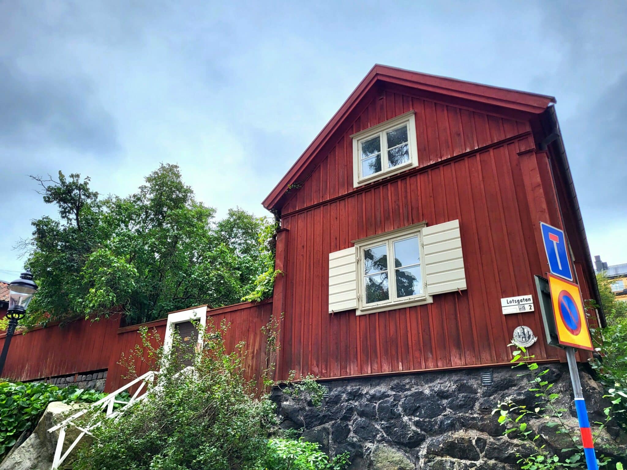 Public street at Lotsgatan and Skeppargränd on Åsöberget. Compare the wooden houses from the walking route, keeping residential entrances and steps clear.