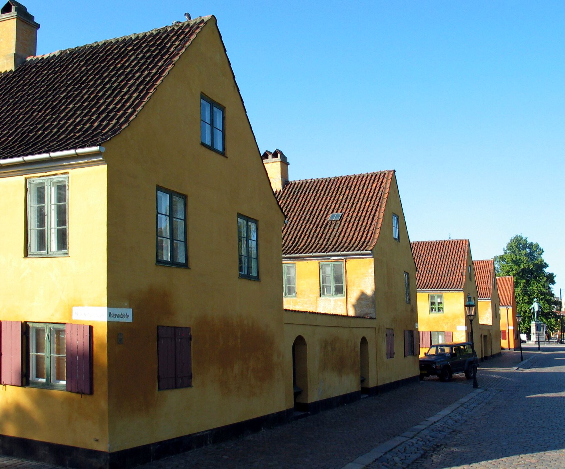 Public pavement along Sankt Pauls Gade beside Nyboder’s yellow houses, near number 24; remain outside residential entrances.