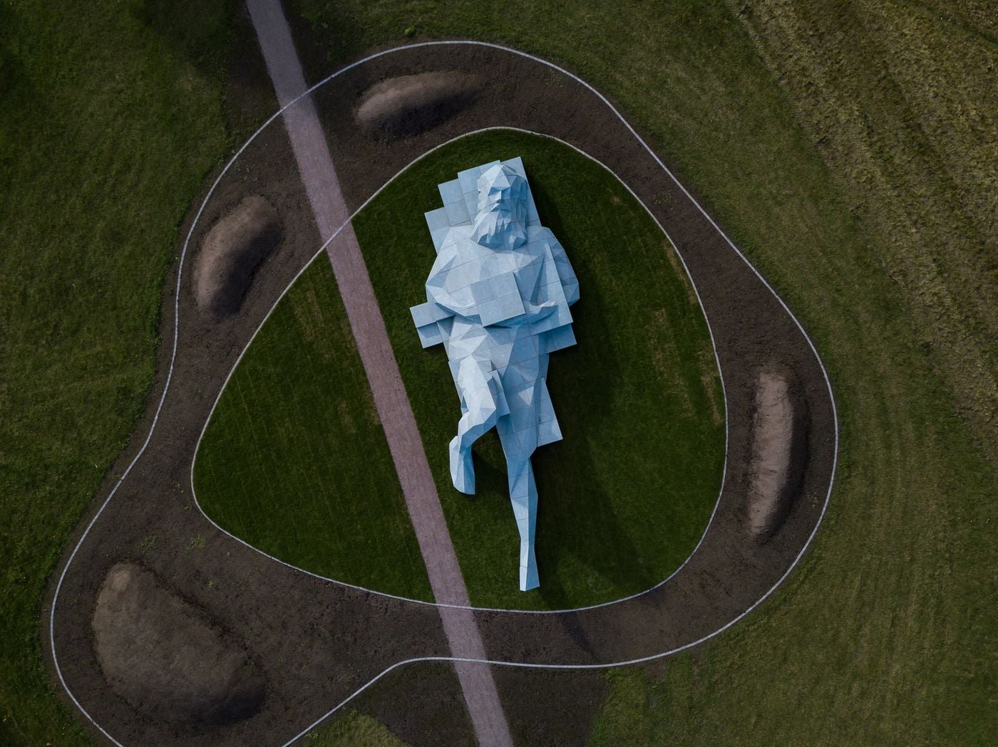 Public path beside the reclining blue giant on Pelousen below the former care home in Vårberg. View the figure from ground level; climbing is not needed for this quest.